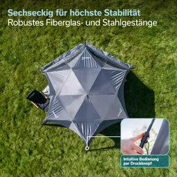Sechseckiges Sonnenschutzzelt aus grauem Material auf grünem Gras, mit einem stützenden Gestänge aus Fiberglas und Stahl.