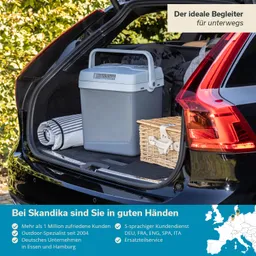 Kühlbox und Korb in einem Kofferraum, mit Decke und grüner Umgebung im Hintergrund. Textinformationen im Bild.