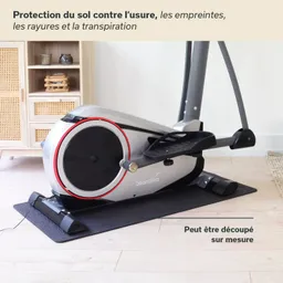Elektromagnetisches Fitnessgerät mit einem schwarzen Fußpolster und grauem Gehäuse, platziert auf einem hellen Holzfußboden.