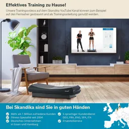 Wohnzimmer mit einem Fitnessgerät, einer Pflanze, einem Stuhl und einem Fernseher, der Trainingsanleitungen zeigt.