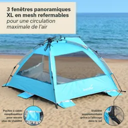 Zelt in Hellblau mit mesh Fenstern am Strand. Sand am Boden und Meer im Hintergrund. Stabilisierungsdetails sichtbar.