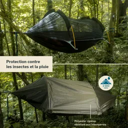 Hängematte in einem Wald mit Insektenschutz und Regenabdeckung, umgeben von grünen Pflanzen.
