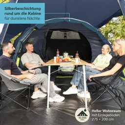 Im Zelt sitzen vier Personen um einen Tisch, auf dem Obst und Getränke stehen. Der Innenraum ist dunkel, mit einem hellen Boden.