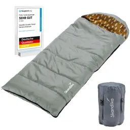 Schlafsack in grauer Farbe mit orangefarbener Innenseite, neben einem kompakten Packsack und einem Qualitätssiegel.