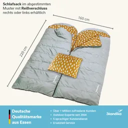 Schlafsack mit abgerundetem Kopfbereich, grauer Außenfarbe und gemusterter Innenverkleidung. Kissen in Orangeton.