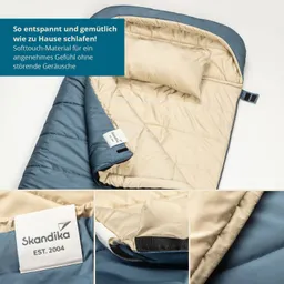 Schlafsack in Blau und Beige, geöffnet mit einer kleinen Kopfstütze, sichtbar Label von Skandika. Text beschreibt das Material.