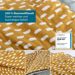 Deckenstoff aus 100 % Baumwollflanell in gelb mit weißen Mustern. Links Label mit Bewertung „SEHR GUT“.