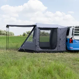 Zelt in Grau mit Transparentelementen, angrenzend an einen blauen Fahrzeug, auf einer grünen Wiese unter Wolken.