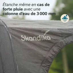 Zeltmaterial mit Wassertropfen, Markierung „Skandika“ und Text über Wasserdichtigkeit bis 3000 mm. Unscharfer Hintergrund.