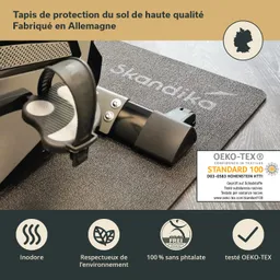 Schutzmatte aus schwarzem Material mit runder Struktur und einem Gerät (vermutlich Teil eines Fitnessgeräts) darauf.