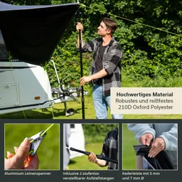 Person richtet ein Zelt oder eine Markise mit einem Stab und einem Leinen verspannter im Freien auf. Im Hintergrund ein Wohnwagen.