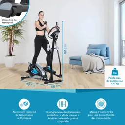 Ellipsentrainer mit einer Person, die darauf steht. Im Hintergrund eine Pflanze und ein Sofa. Maße und Features angegeben.