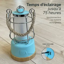 Blaue Tischlampe mit Metallgitter und Hanfgarn-Aufhängung auf einem Holzsockel, dazu Ladeanschluss sichtbar.
