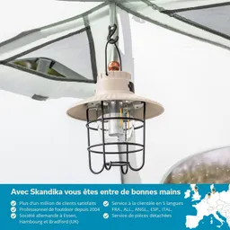 Hängende Lampe mit einem metallenen Gitter und einem schlichten Lampenschirm unter einem Zelt.