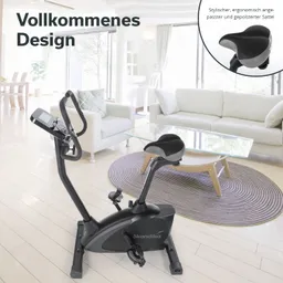 Fahrradergometer in einem hellen Raum mit Sofa, Glastisch und Teppich. Ergonomischer Sattel und Display sichtbar.