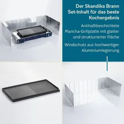 Schwarze Plancha-Grillplatte mit strukturierter und glatter Fläche, umgeben von einem Alu-Windschutz, auf hellem Hintergrund.