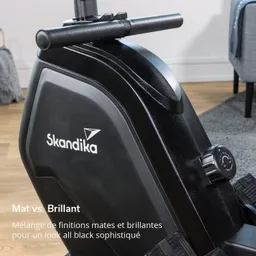 Schwungrad eines Fitnessgeräts in Schwarz mit der Aufschrift „Skandika“. Matt-schillernde Oberfläche und verstellbarer Widerstandsregler.