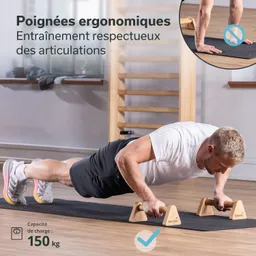 Mann in Sportkleidung macht Liegestütze auf einer Matte mit ergonomischen Handgriffen aus Holz. Hintergrund zeigt eine Fitnessumgebung.