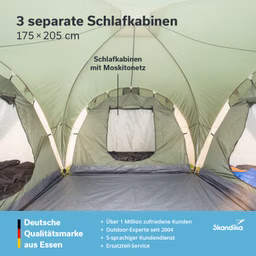 Zeltinnenseite mit drei separaten Schlafkabinen, ausgestattet mit Moskitonetzen. Grüne Zeltwände und grauer Boden.
