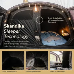Zelt mit schwarzer Innenausstattung und Schlafbereich, beleuchtet von einer Lampe. Integrierte Trennwand, verschiedene Fensteroptionen.