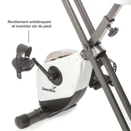 Schwinn-Fahrradtrainer mit rutschfestem Pedal und schwarzen Tretflächen. Logo "Skandika" auf der weißen Gehäusefront.