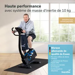 Person sitzt auf einem Heimtrainer mit einem Handtuch über dem Lenker, in einem hellen Raum mit Fenster und Pflanzen.