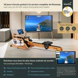 Rudergerät aus Holz mit Wasserbehälter, davor ein Fernseher, der eine Strandszene zeigt. Smartphone und Tablet auf einem Tisch.