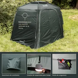 Ein grünes Zelt auf einer Wiese mit verschiedenen Merkmalen: seitliche Lüftungsöffnungen, ein Haken für eine Lampe und eine Taschenablage.