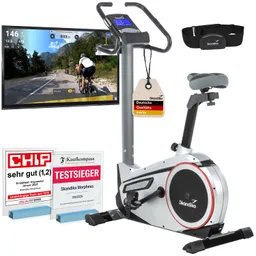 Ergometer in silberner Ausführung mit Bildschirm, Herzfrequenzgurt und mehreren Auszeichnungen im Vordergrund.