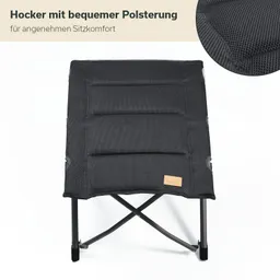 Faltbarer Hocker mit schwarzer, gepolsterter Sitzfläche und Metallgestell. Sichtbare Logo-Detail.
