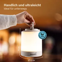 Tragbare Lampe mit weißem Lampenschirm, in der Hand gehalten. Maße: 15 cm hoch, Durchmesser 12 cm. Marke: Skandika.