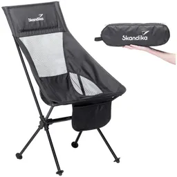 Schwarzer Campingstuhl mit Netzmaterial und einem Stauraum, daneben eine Hand, die eine schwarze Tragetasche hält.