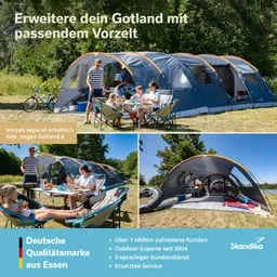 Großes Zelt in der Natur mit Vorzelt. Familie am Tisch mit Getränken und Essen. Sitzgelegenheiten und Fahrrad sichtbar.