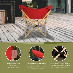 Roter Klappstuhl aus Stoff mit braunem Holzgestell auf einer Holzterrasse. Im Hintergrund stehen Möbel und eine Glaswand.