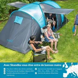 Zelt in blauer und grauer Farbe auf einer Wiese. Zwei Personen sitzen an Klappstühlen, eine Person ist im Zelt sichtbar.