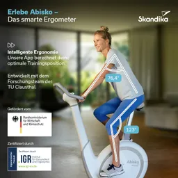 Ergometer mit einer Person, die darauf sitzt, in einem hellen Raum mit Pflanzen im Hintergrund. Text über das Produkt.