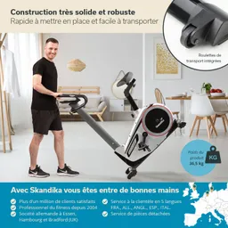 Fitnessgerät in einem modernen Raum. Eine Person steht an einem Ergometer und hält die Griffe. Der Raum hat helle Wände und dekorative Elemente.