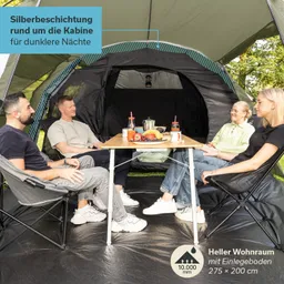 Ein Zelt mit vier Personen, die an einem Tisch sitzen. Auf dem Tisch befinden sich Essen und Getränke.