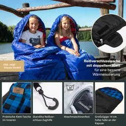 Zwei Kinder sitzen auf einem Holzsteg am Wasser, eingehüllt in blaue Schlafsäcke. Im Bild sind Details zu den Schlafsäcken abgebildet, wie eine Klett-Tasche und eine Waschmaschinenfestigkeit.