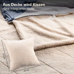 Decke und Kissen aus weichem Material, Kissen neben der Decke mit Maßen 44 cm x 47 cm, helle Farben.