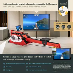 Rudergerät in roter Farbe mit Monitor im Hintergrund, der eine Ruderbootfahrt zeigt. Informationen über ein Fitnessprogramm sind sichtbar.