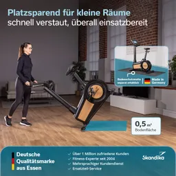 Ein Fitnessgerät wird von einer Person in einem Raum mit Fenster und einem Sofa bewegt. Holzboden und helles Licht sind sichtbar.