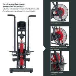 Fitnesstrainer mit zwei Griffen, einem großen Ventilator und stabilen Fußschlaufen. Technische Details sind rechts aufgelistet.