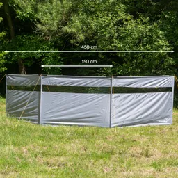 Graue Abtrennung mit zwei Fensteröffnungen, maßen 450 cm x 150 cm, auf einer Wiese umgeben von Bäumen.