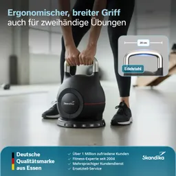 Schwarz-roter Kettlebell mit breitem Griff aus Edelstahl auf einem Fitnessboden. Angedeutete Person steht davor und greift.