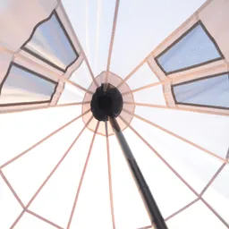 Sicht von unten auf einen Sonnenschirm mit transparentem Stoff und einem zentralen Stab, der die Struktur stützt.