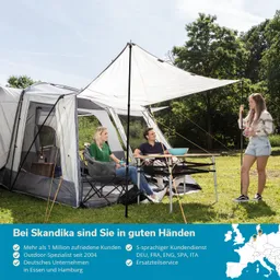 Teepee-Zelt im Freien mit zwei Personen, die auf Stühlen sitzen, und einer Person, die spricht. Bäume im Hintergrund.