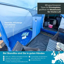 Zelt innen mit blauer Schlafkabine und Matratze, daneben ein Tisch mit Bechern, Kissen und Buch. Auto im Hintergrund.