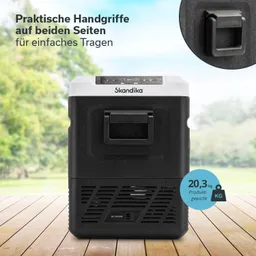 Kühlbox in Schwarz mit weißen Akzenten, ausgestattet mit praktischen Handgriffen und einem digitalen Display. Hintergrund in der Natur.