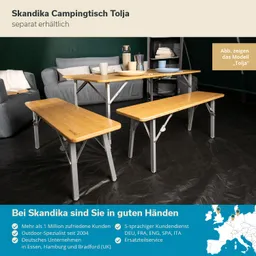Klappbarer Campingtisch mit Holzplatte und zwei Bänken in einem Zelt. Im Hintergrund stehen ein Sofa und Regale.